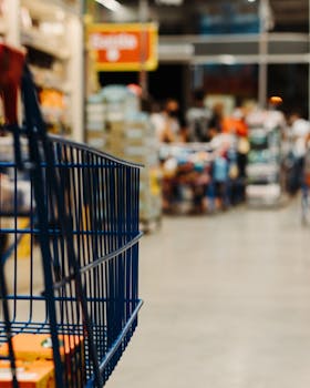 Shopping cart in a busy Brazilian supermarket aisle with blurred background.