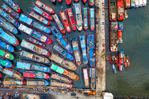 Free Aerial view of vibrant fishing boats in Jakarta's busy harbor, showcasing maritime activity. Stock Photo