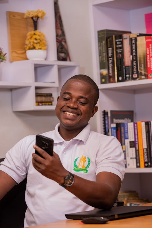 A Man in White Polo Shirt Holding Cellphone