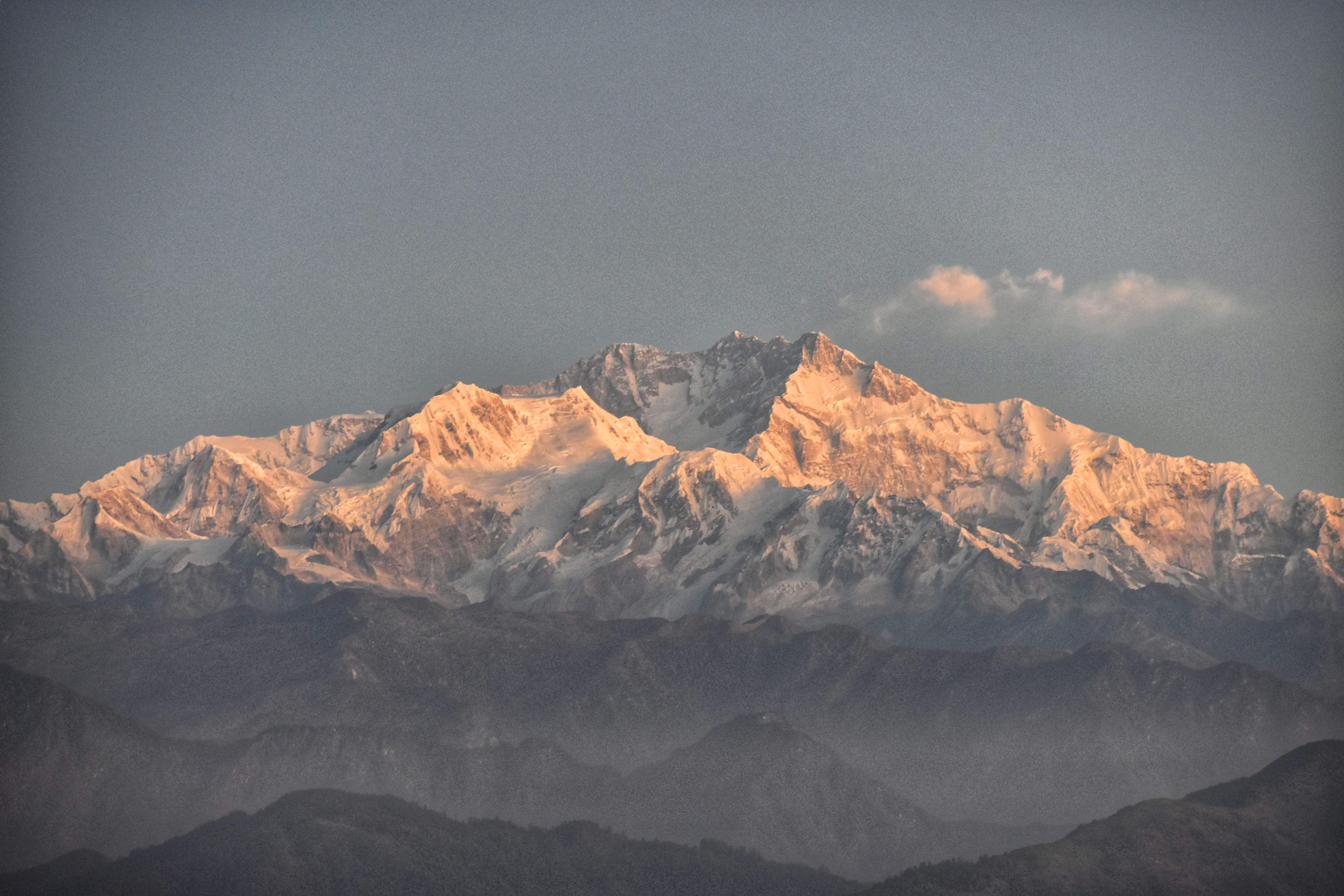Breathtaking snowy peaks of Kangchenjunga captured at sunset, showcasing serene beauty.