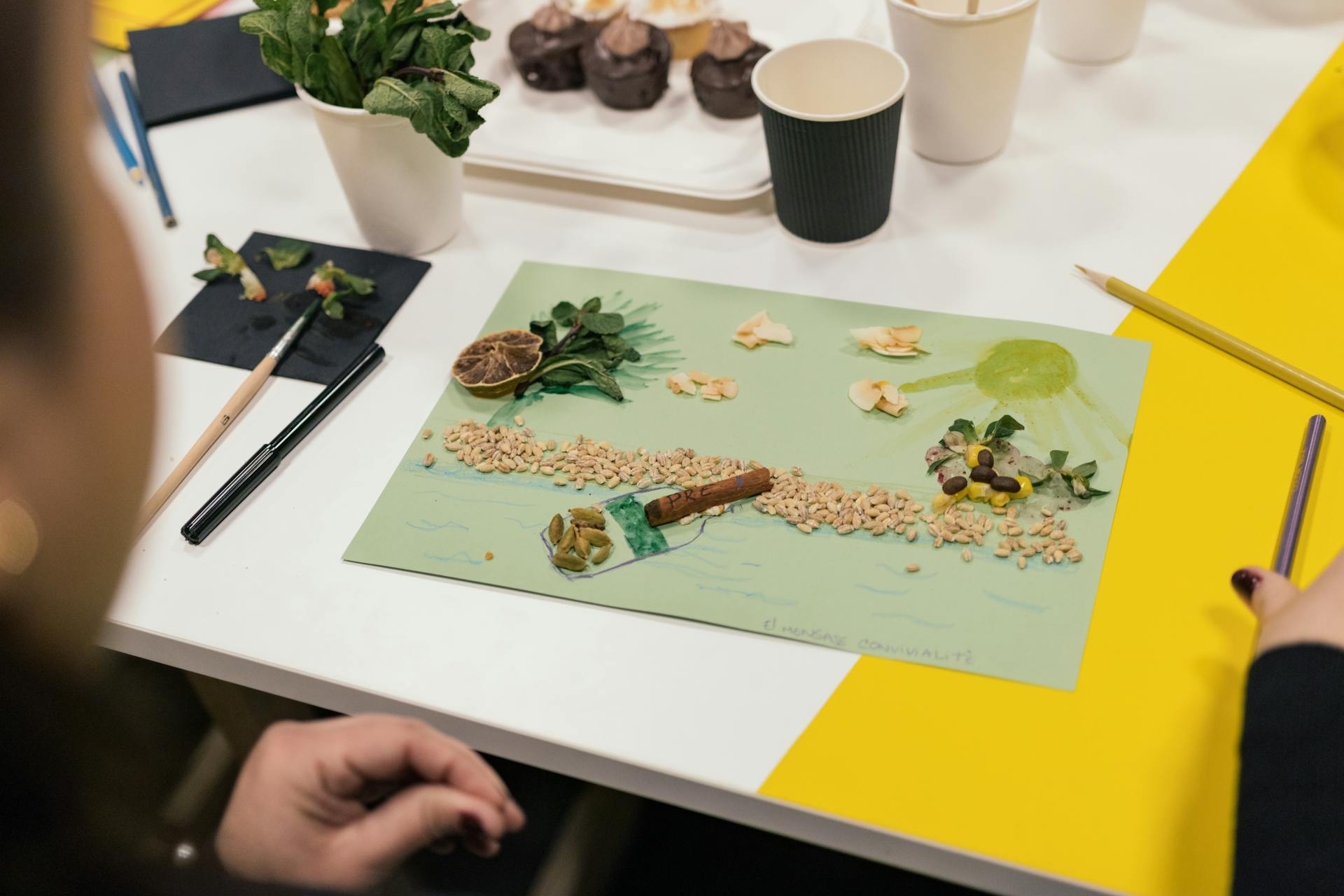 Artistic collage made with natural materials like seeds and leaves on paper.