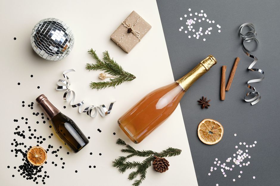Festive flat lay with champagne bottles, disco ball, and holiday decor, perfect for New Year celebrations.
