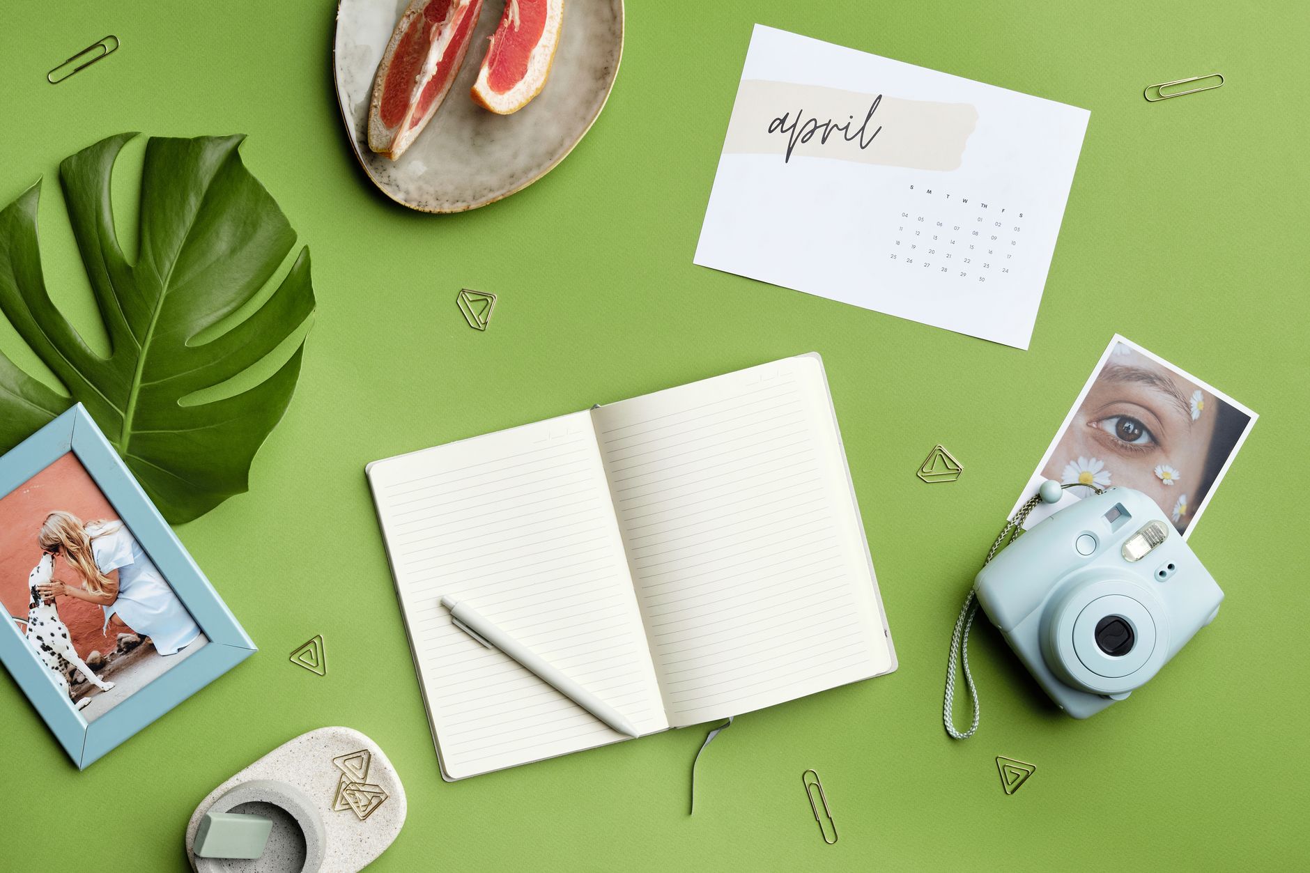 Flat lay of creative workspace with journal, instax camera, and grapefruit. Ideal for lifestyle and productivity themes.. pex