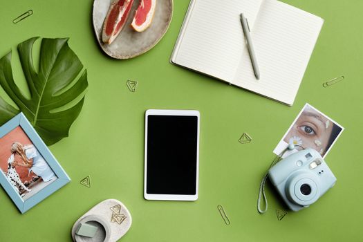 A flat lay featuring stationery, a camera, and a tablet on a green background, perfect for creative concepts.. pexels, flat, 