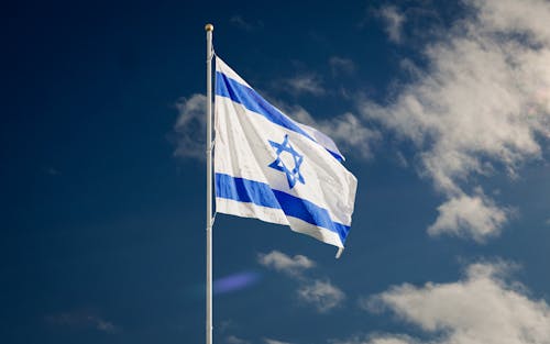 Free Israel Flag On a Flagpole Under the Blue Sky Stock Photo