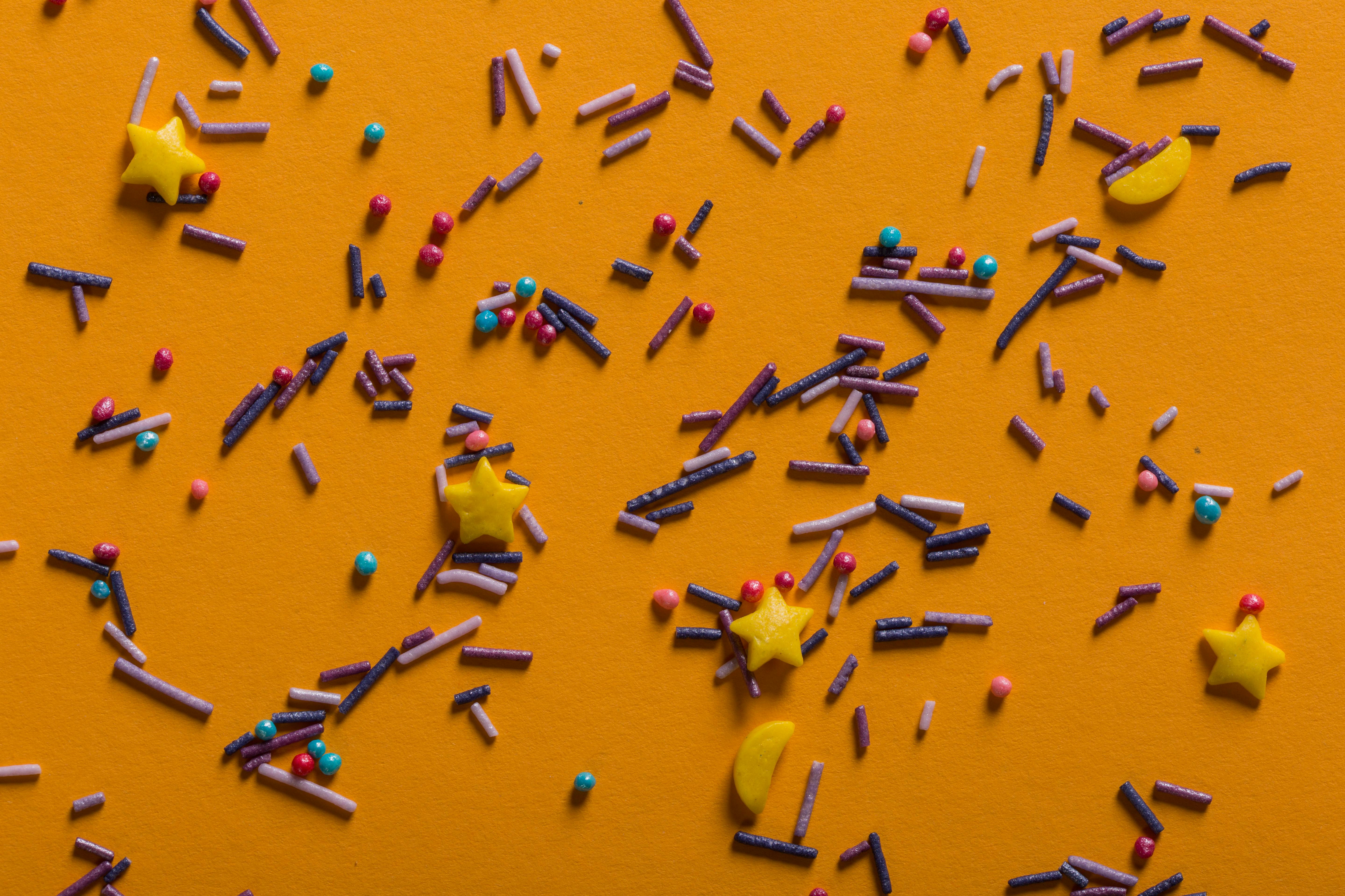 Colorful Confetti on Orange Background · Free Stock Photo