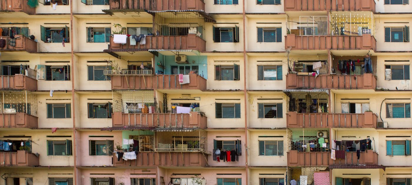 A residential apartment tower facade in Kuala Lumpur — homes stacked above a retail and F&B podium