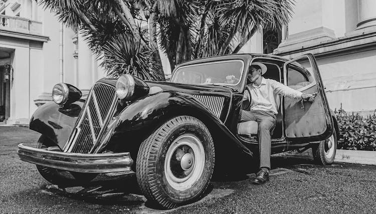 Man Getting Out Of Vintage Car