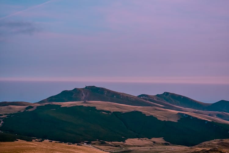 Sandy Mountains Near Ocean Under Purple Sky At Sundown