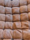 Textured background of aged brown sofa upholstery with thin threads and square shaped ornament