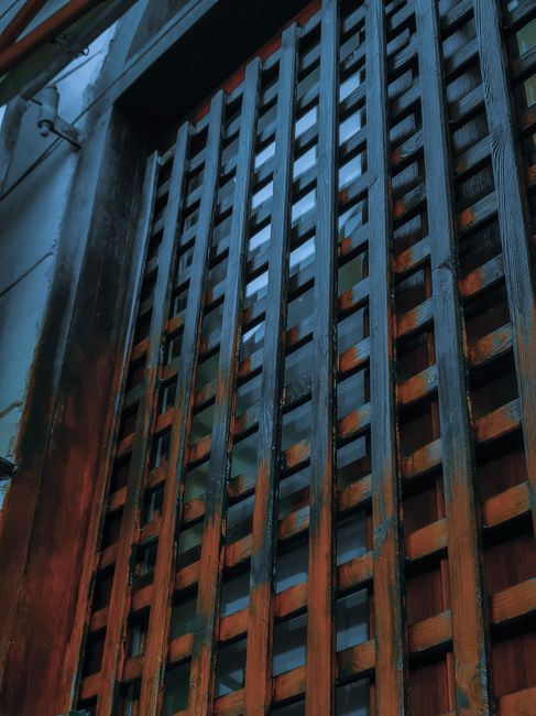 From below of aged multistage house exterior with windows and weathered front wall in night city