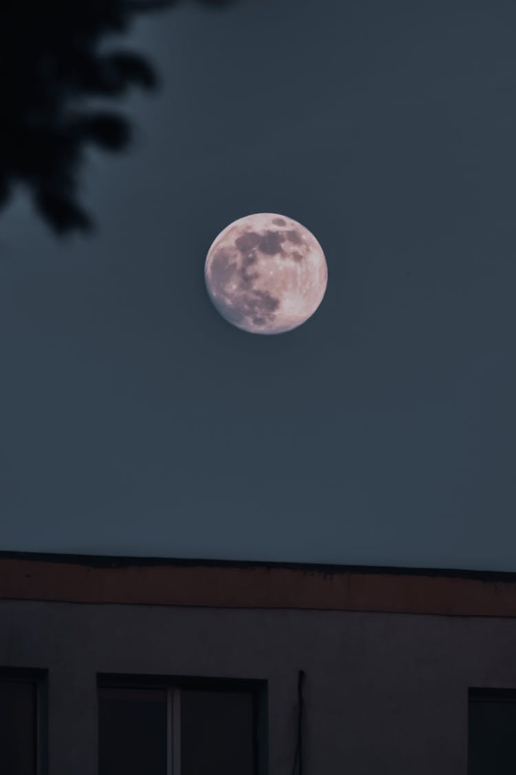 Full Moon In Night Sky Over Urban Building