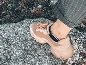 Crop faceless person leg in sneaker standing on stone
