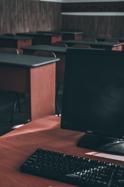 Free Computer with monitor and keyboard on desk in classroom Stock Photo