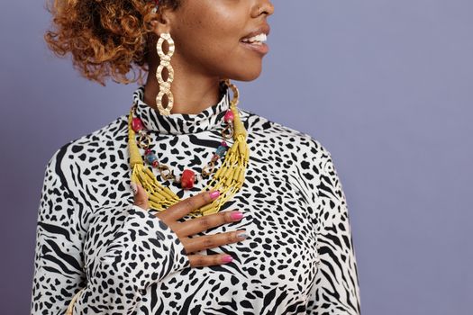 Fashion-forward woman in leopard print attire showcases vibrant jewelry.