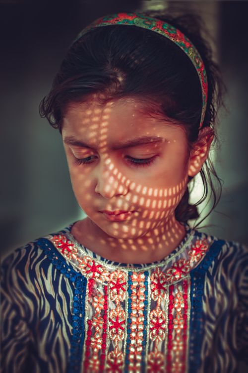 Free Close-up portrait of a young girl in Mamunkanjan, Pakistan, beautifully lit with patterned shadows. Stock Photo