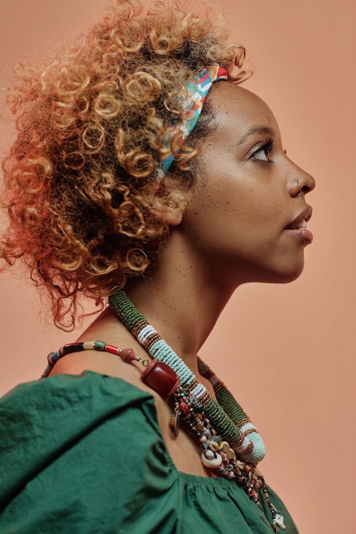 bandana hairstyles 2026 woman with curly hair wearing headband contemplative portrait