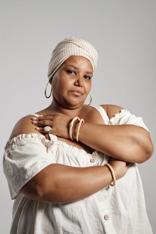 Woman in White Sleeveless Dress Wearing White Headwrap