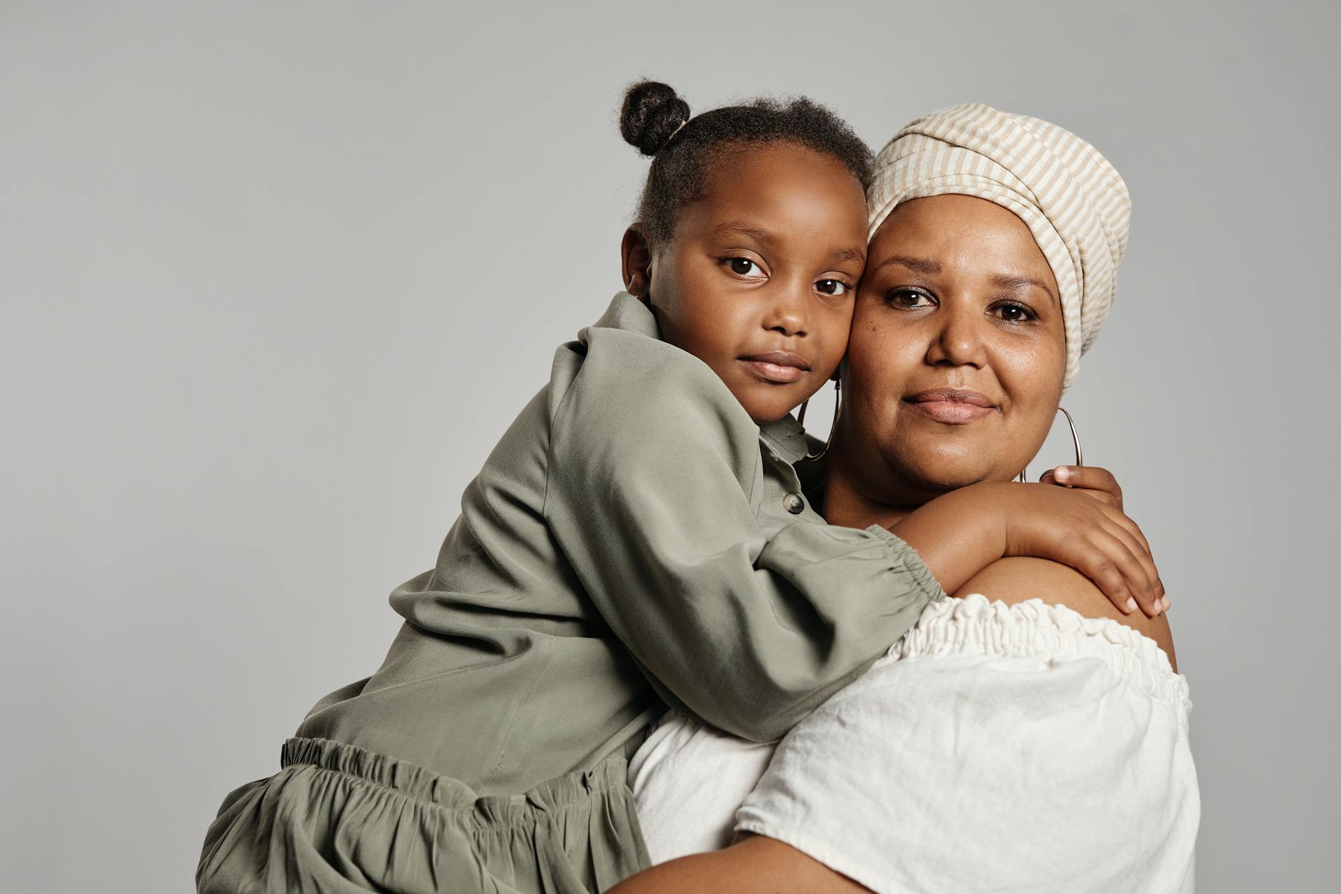 Heartwarming portrait of a mother and daughter lovingly embracing, capturing familial affection.