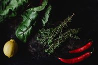 俯视深色背景上的新鲜甜菜、辣椒、百里香和柠檬