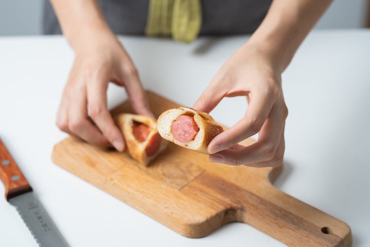 Photograph Of A Person's Hand Holding A Hotdog