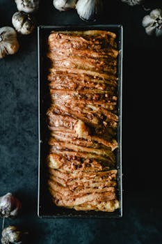 Tantalizing savory garlic bread freshly baked in a classic tin, perfect for your next meal.