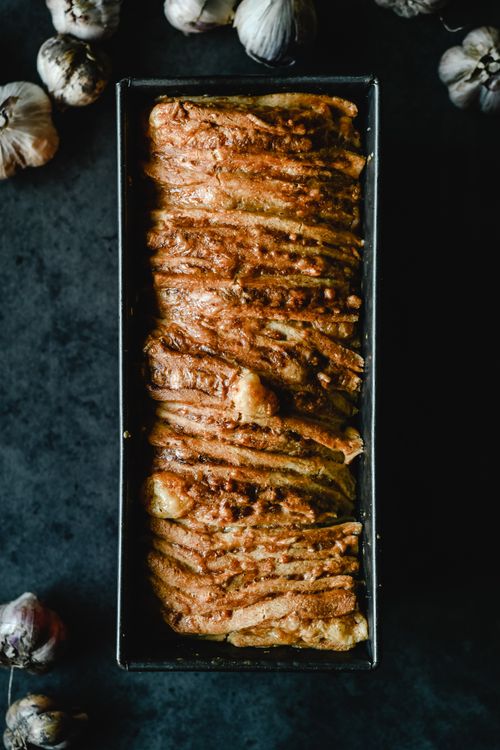 Free Tantalizing savory garlic bread freshly baked in a classic tin, perfect for your next meal. Stock Photo