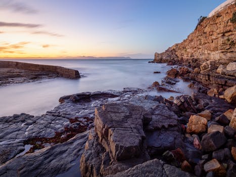 Beautiful coastal rocks at sunrise in Hermanus, South Africa, showcasing natural beauty and tranquility.