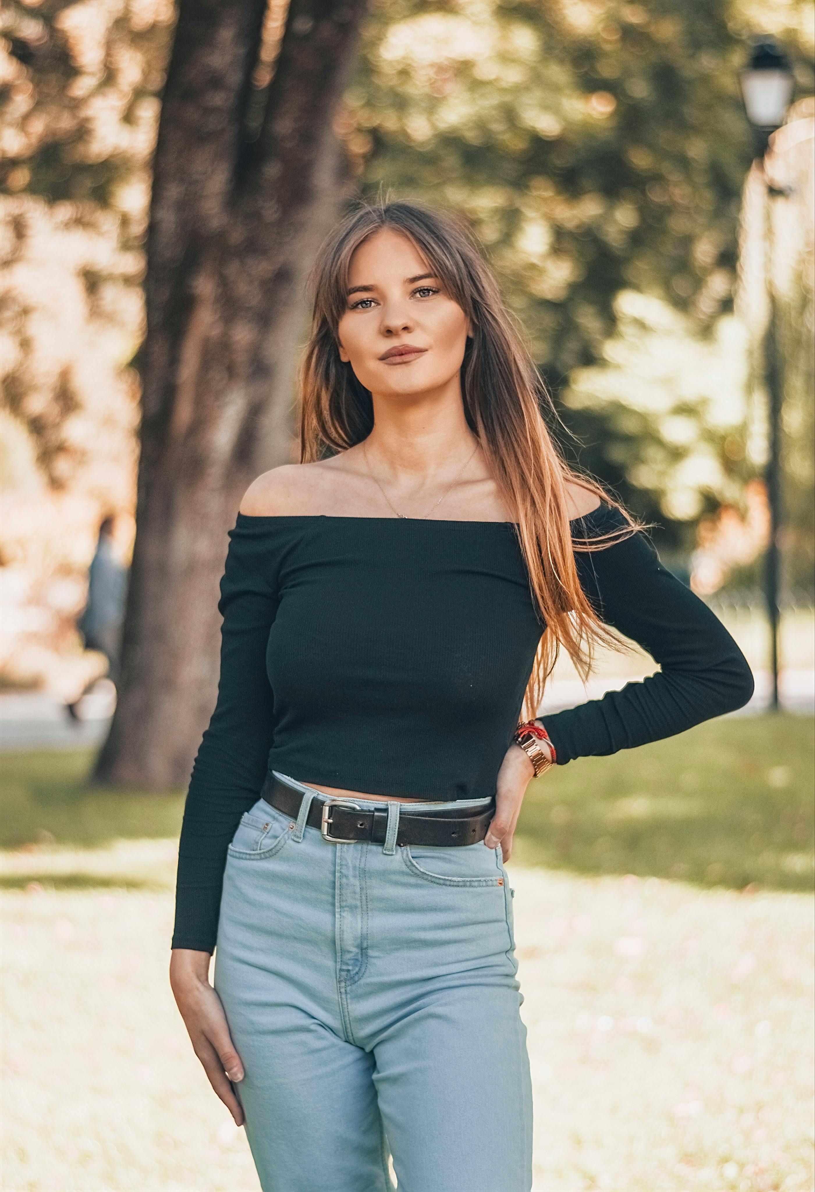 A Woman Wearing an Off-Shoulder Top and Denim Jeans · Free Stock Photo