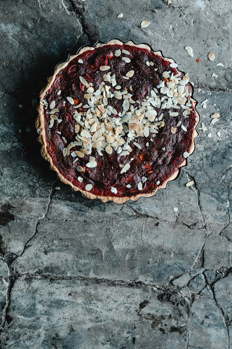 Top View Of A Beetrot Tart With Almond Sprinkle On Concrete Background