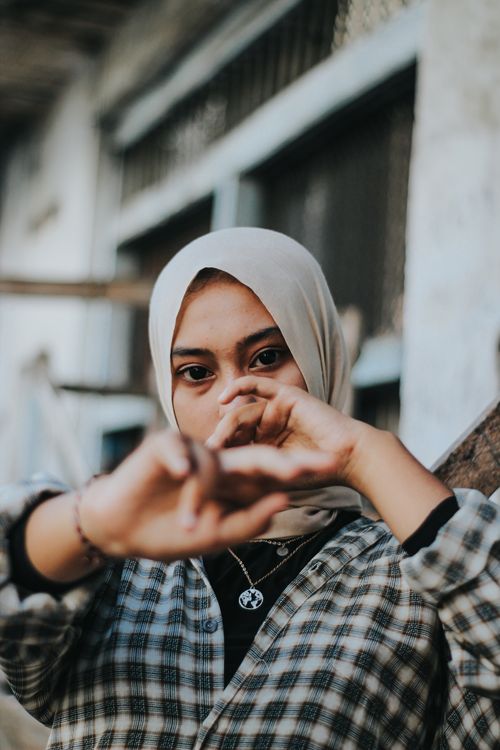Free Portrait of a young Muslim woman in a hijab with her hands framing her face. Stock Photo