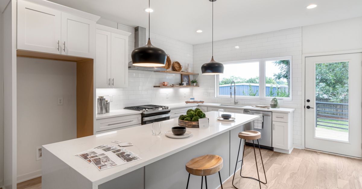 Modern Scandinavian kitchen with white cabinets and black pendant lights