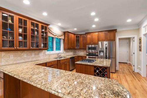 Free Spacious luxury kitchen featuring wooden cabinets and granite countertops. Stock Photo