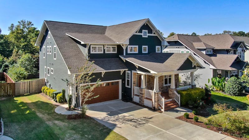 Craftsman-style home with spacious front porch and manicured lawn