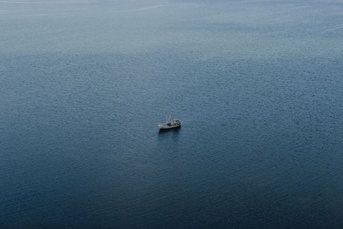 Free A lone fishing boat floats on calm waters in Sääre, Estonia, capturing serene maritime beauty. Stock Photo