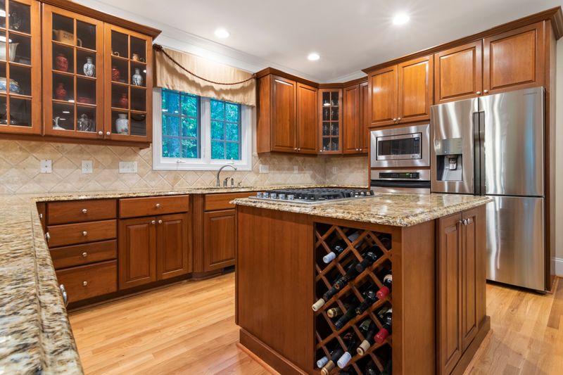 Cocina con alacenas de madera y mesada de granito