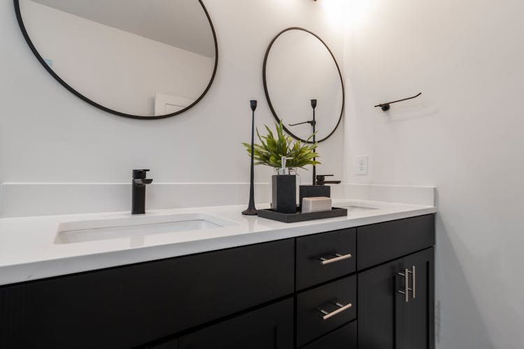 Round Mirrors Above White And Black Wooden Sink Cabinet 