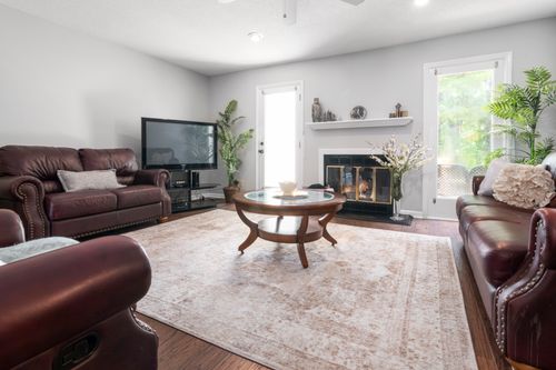 Free Luxurious living room featuring leather sofas, fireplace, and large windows. Stock Photo