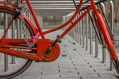 Red Bicycle Parked Beside a Railing