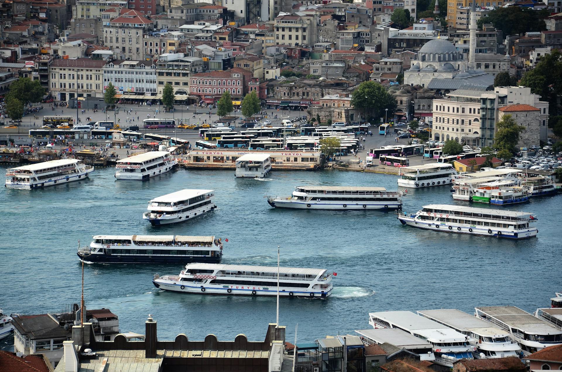 Lively harbor scene with numerous ferries navigating through a bustling city waterfront.