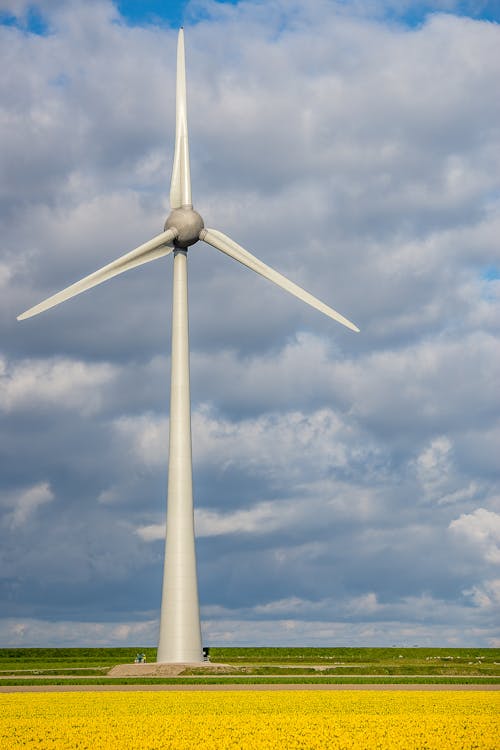 Free A Wind Turbine Under a Cloudy Sky Stock Photo