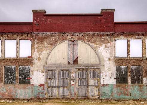 一座废弃的建筑，立面破旧，木门腐朽，尽显衰败之象