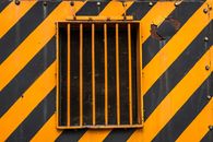 An Orange Metallic Window in a Black and Orange Metal Wall
