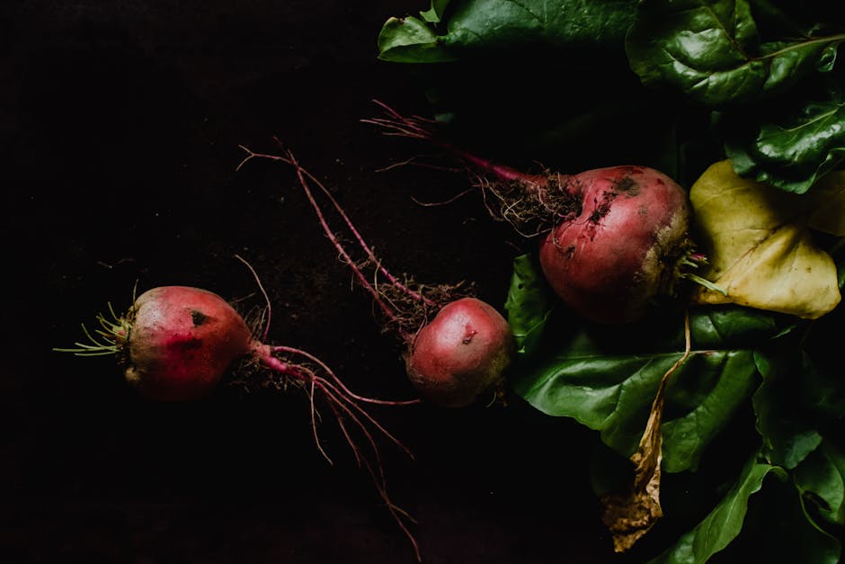 Close-up of fresh organic beetroots with leaves on a dark background, showcasing natural produce.