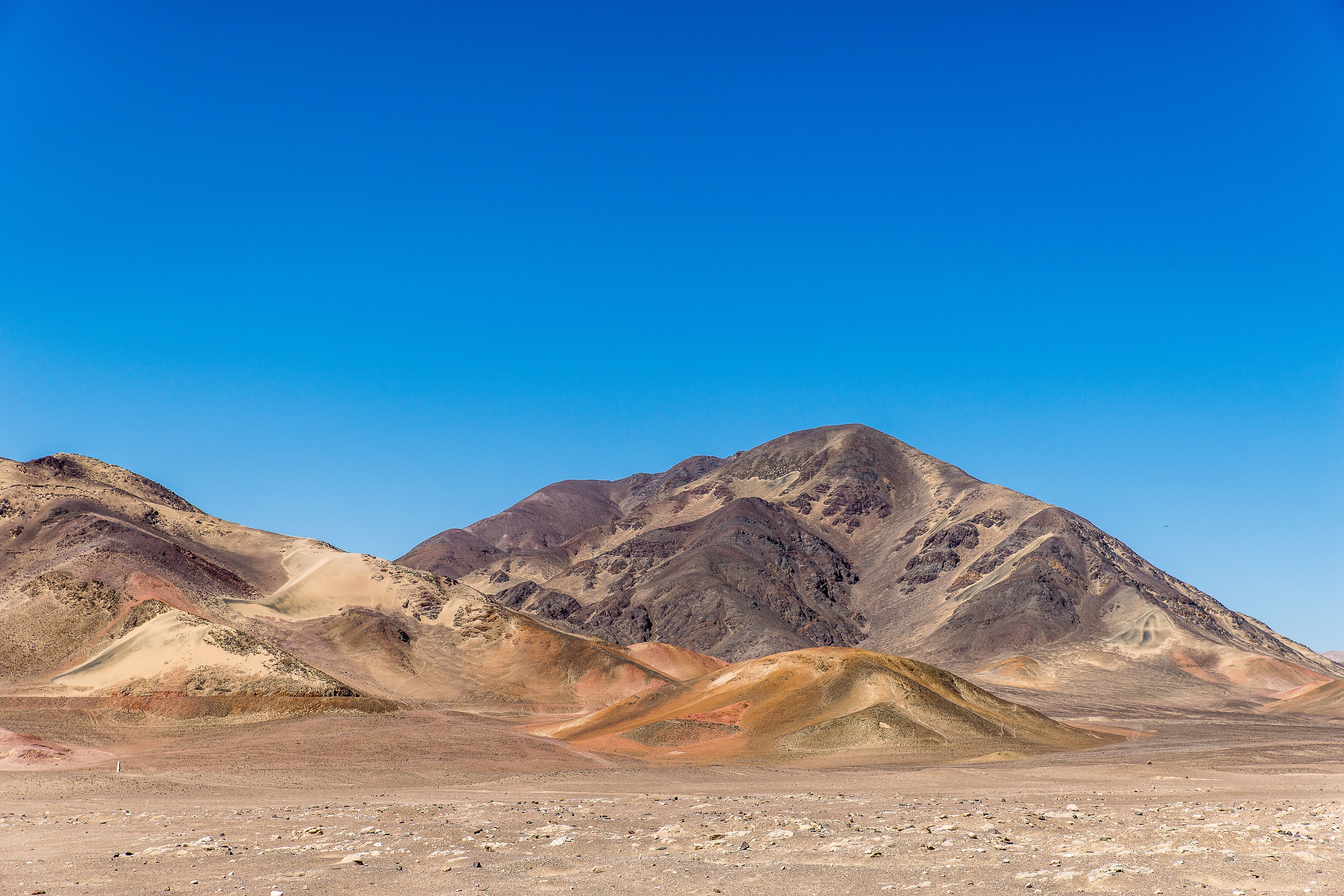 A desert landscape with mountains in the background · Free Stock Photo