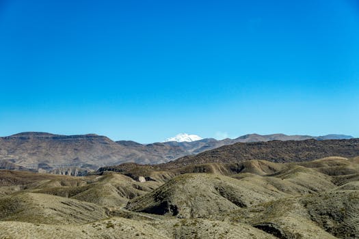 Scenic view of a mountain range with hills and blue sky, capturing natural beauty.
