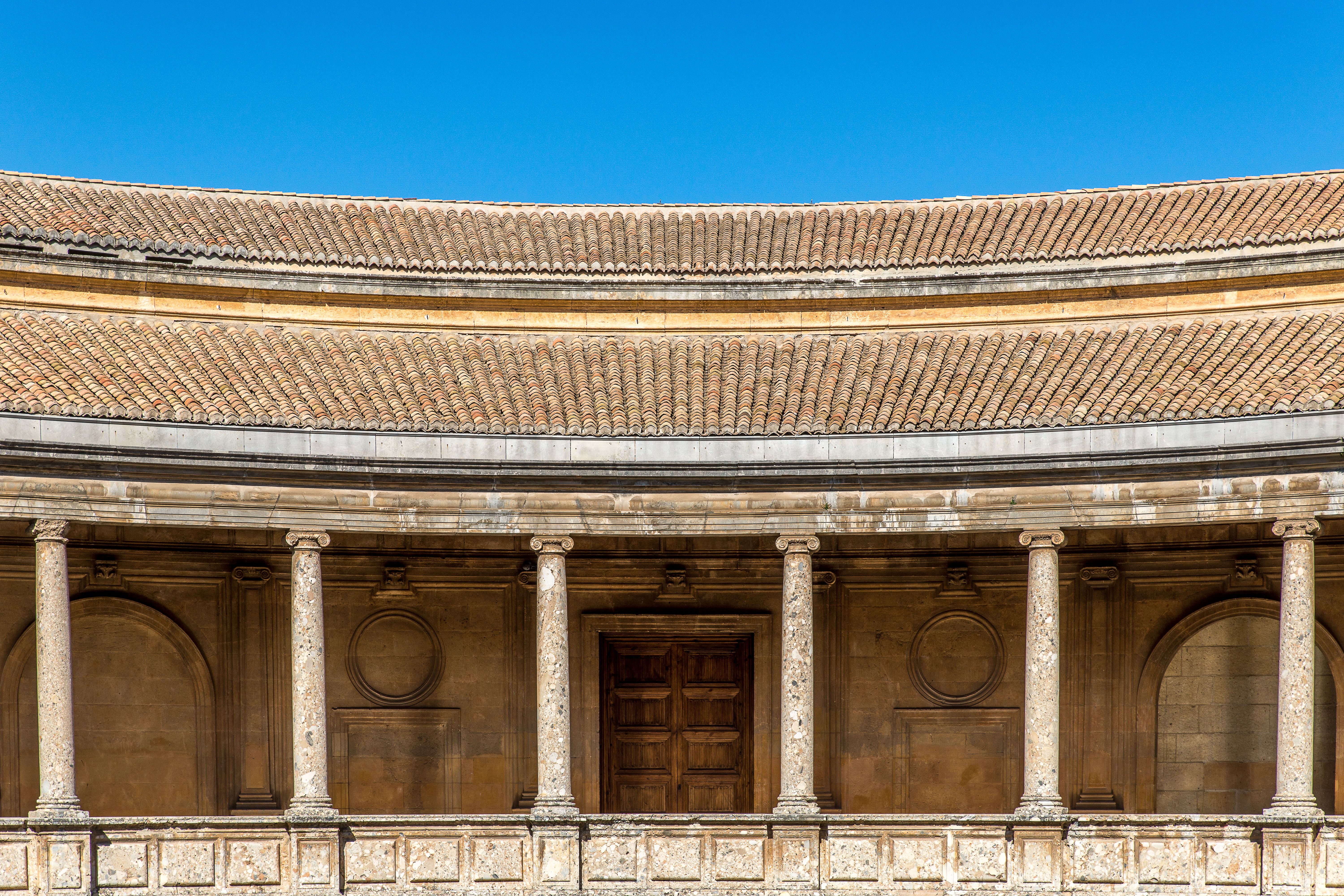 A classic architectural facade featuring circular design and stone columns under a clear blue sky.