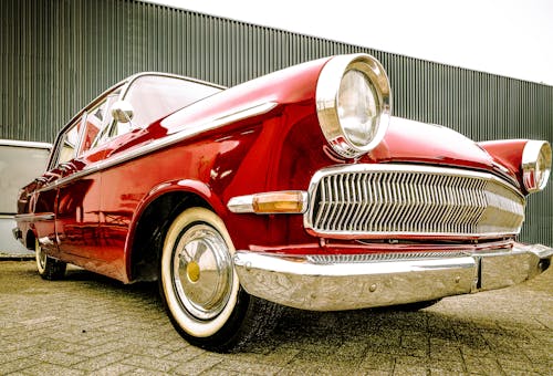 Free A Red Coupe Vintage Car Parked on the Pavement Stock Photo