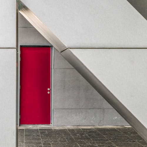 Locked Red Door in Modern Concrete and Metallic Facade