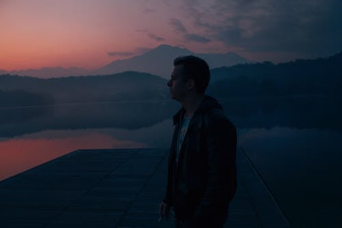 Free Photo of a Man in a Jacket Standing Near a Lake Stock Photo